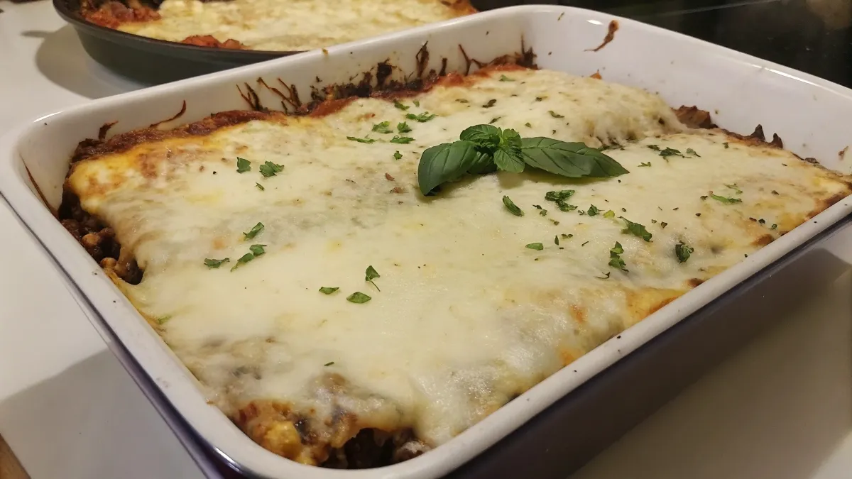 A mouthwatering baked lasagna with creamy layers, golden cheese, and fresh basil, highlighting the Italian way of cooking.
