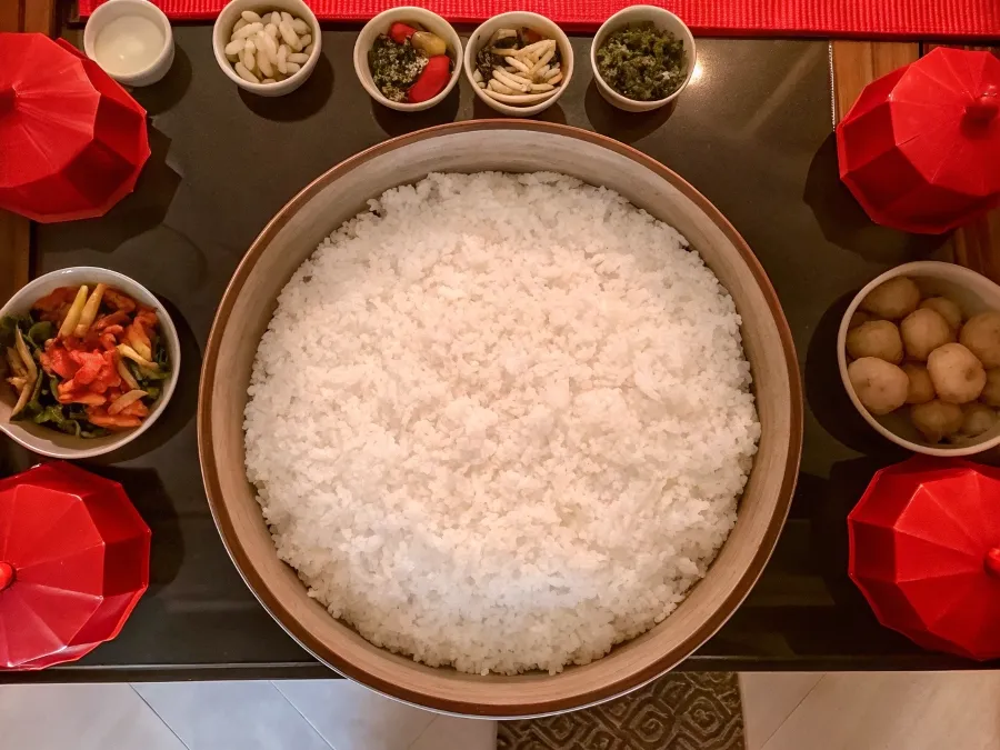 raditional Chinese family meal with white rice, stir-fried vegetables, and cultural decor.